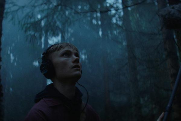 Mies seisoo pimeässä metsässä / Man standing in a dark woods