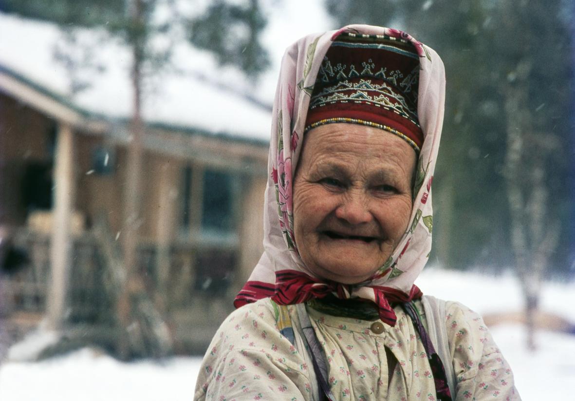 Vanha, hampaaton nainen ulkona talvella.