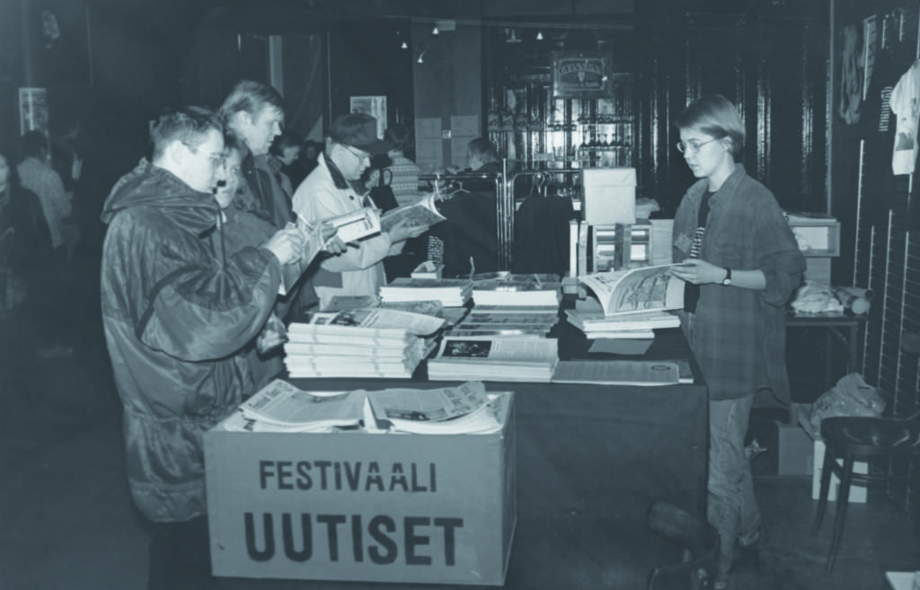 Ihmisiä Tampereen Film Festivalin infotiskin ympärillä.