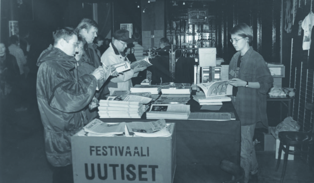 Ihmisiä Tampereen Film Festivalin infotiskin ympärillä.