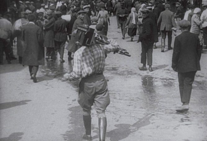 Mustavalkoinen ja vanha kuva, jossa on joukko miehiä kävelemässä.