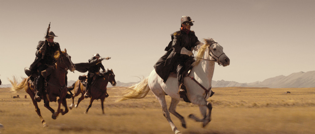 Kolme henkilöä ratsastamassa hevosella puvut päällään.