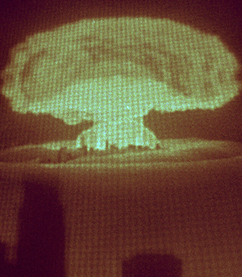 Kaukaa näkyy ydinpommiräjähdyksen sienipilvi.