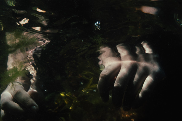 Vaaleat kädet veden alla.